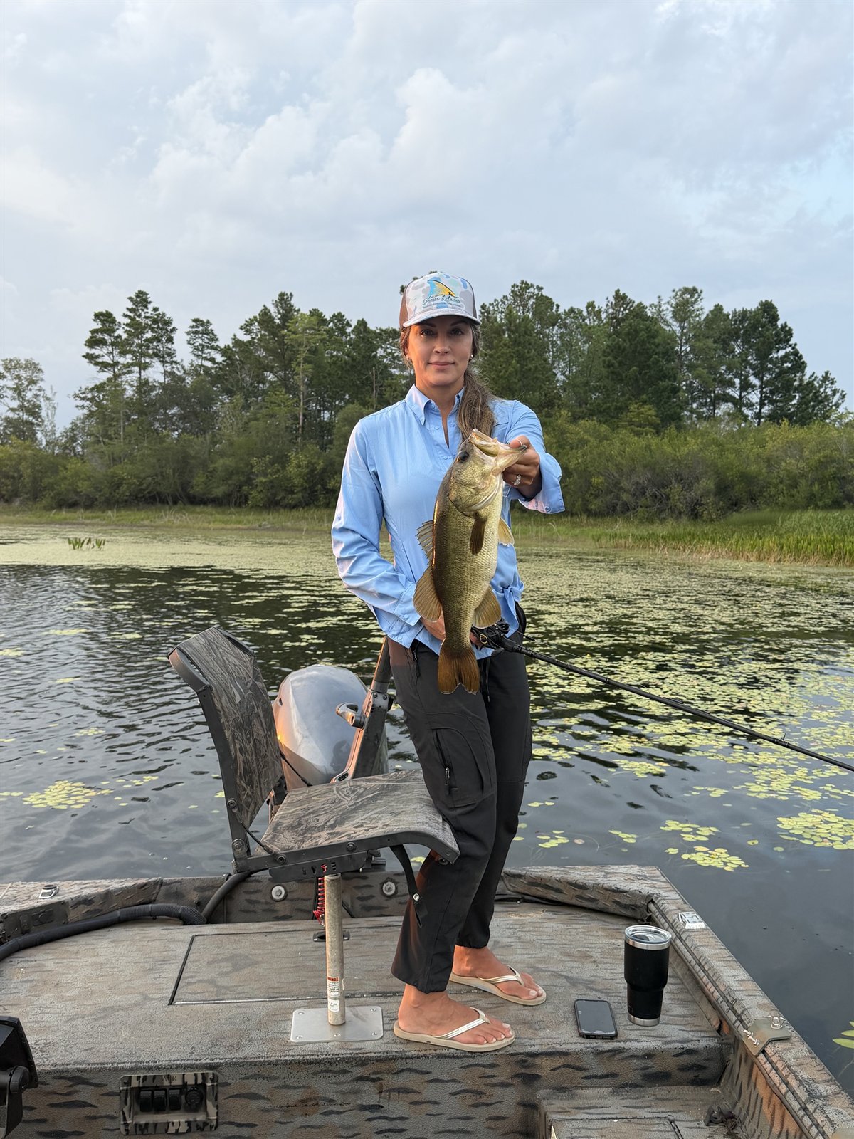Kerri Brown holding a bass on the boat